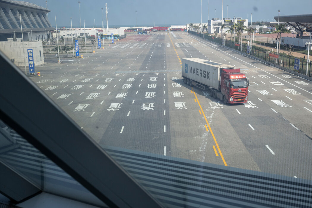 海关工作人员检查离开海南的卡车,以防免税商品被走私到大陆。 海关工作人员检查离开海南的卡车,以防免税商品被走私到大陆。