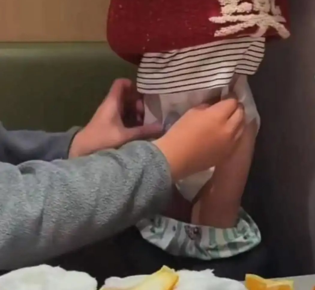江苏徐州一家海底捞哩,有一名幼童站在座位上,旁边有男子正协助更换尿布,随后幼童将... 江苏徐州一家海底捞哩,有一名幼童站在座位上,旁边有男子正协助更换尿布,随后幼童将...