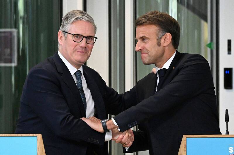 英国首相施凯尔（左）与法国总统马克宏（右），10日在伦敦举行第37届英法高峰会，会后发表领袖宣言，重申对维护朝鲜半岛、南海与东海，以及台海和平稳定的承诺，呼吁以和平方式解决两岸议题。（路透）