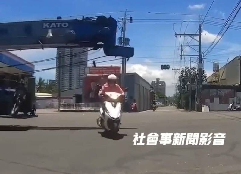 高雄1辆吊车路口闯红灯迎面来，女骑士低头闪过吊臂惊险保命。
（撷取自社会事新闻影音）