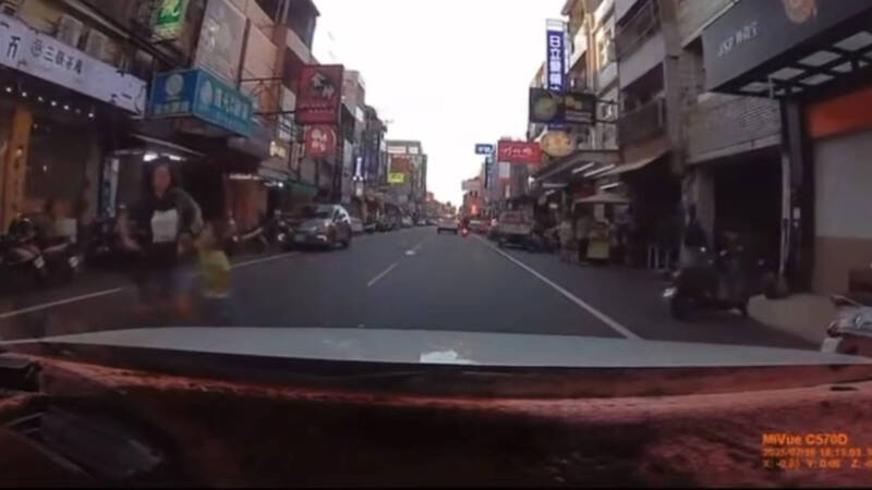 妈妈左右手各牵一名小孩闯马路。（民众提供）