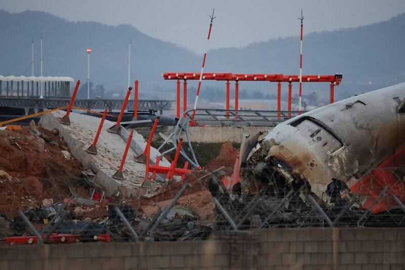 济州航空客机冲出务安机场跑道，撞上设有导航设备的水泥堤防，残骸现场一片焦黑，酿成严重死伤。（路透档案照）