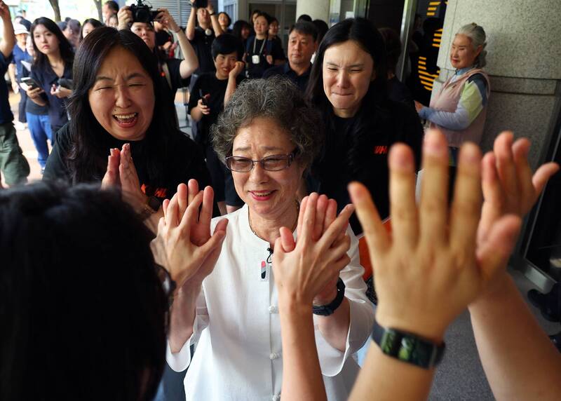 61年前因咬断性侵未遂者舌头而遭定罪的崔末子（中），23日在釜山地方法院出席重审听证会后，被支持者的掌声所包围。（法新社）