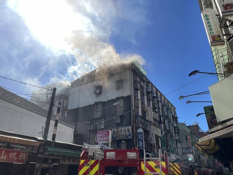 新北中和一間公寓頂樓竄出濃煙，疑因女屋主煮食不慎導致油鍋起火，造成雙手灼傷。（記者陸運鋒翻攝）