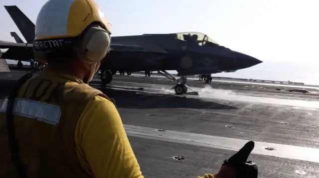 某美军航空母舰上调度员指挥一架F-35战斗机移动(美国中央司令部2026年2月28日发布影片截屏)