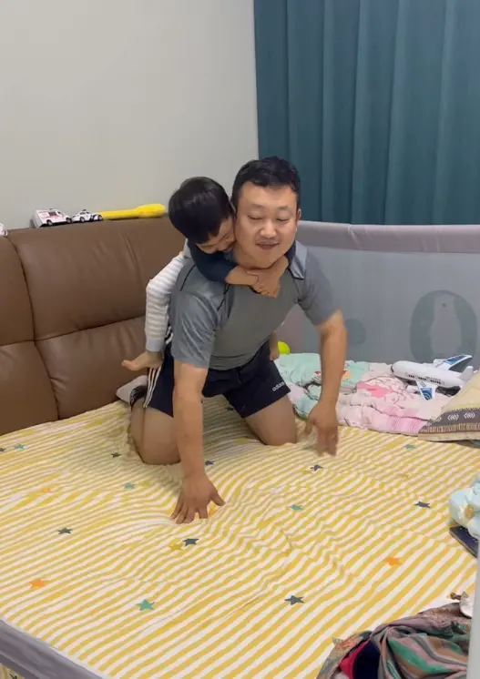 △李先生和儿子在家玩耍。