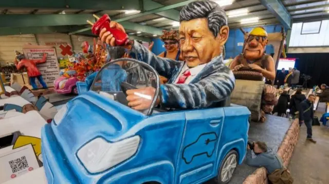 2024年2月6日,德国美因茨,在即将到来的玫瑰星期一游行之前,一辆描绘中国国家主席习近平拔掉电动汽车插头、将德国汽车制造商甩在身后的花车将参与游行。